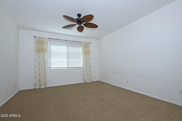 carpeted empty room featuring a ceiling fan and baseboards