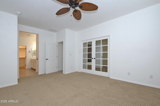 spare room featuring light carpet, french doors, visible vents, and baseboards