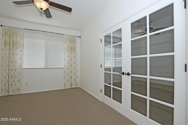 carpeted empty room with a ceiling fan, french doors, and baseboards