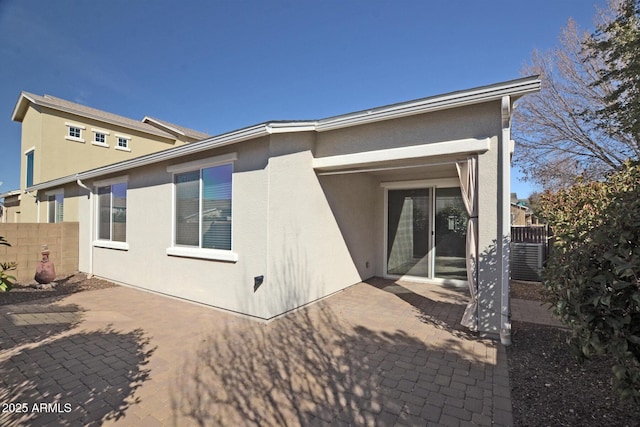 back of house featuring cooling unit, a patio area, fence, and stucco siding