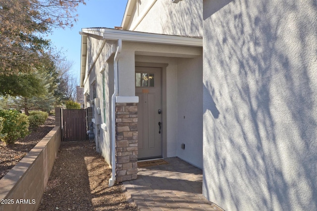 property entrance with stone siding and stucco siding