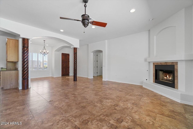 unfurnished living room featuring tile flooring and ceiling fan with notable chandelier