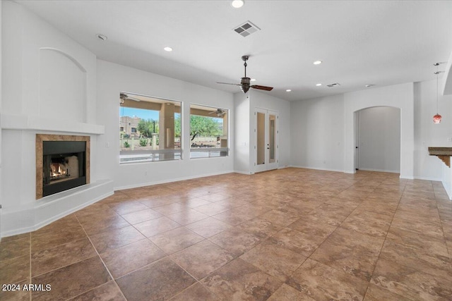 unfurnished living room with ceiling fan and tile floors