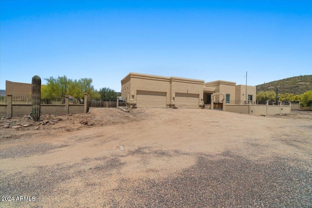 view of yard with a garage, dirt driveway, and fence