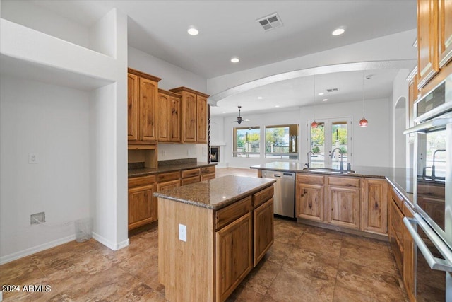 kitchen with sink, appliances with stainless steel finishes, a center island, and tile flooring