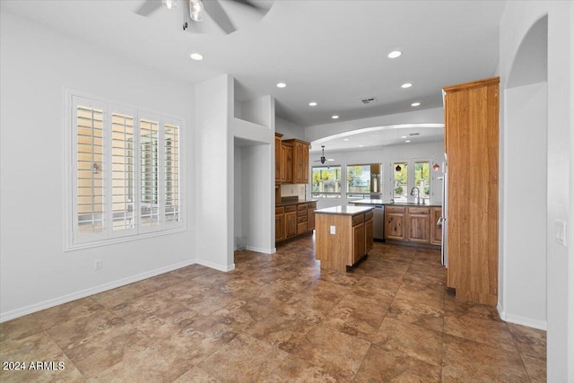 kitchen featuring sink, ceiling fan, tile floors, and a kitchen island