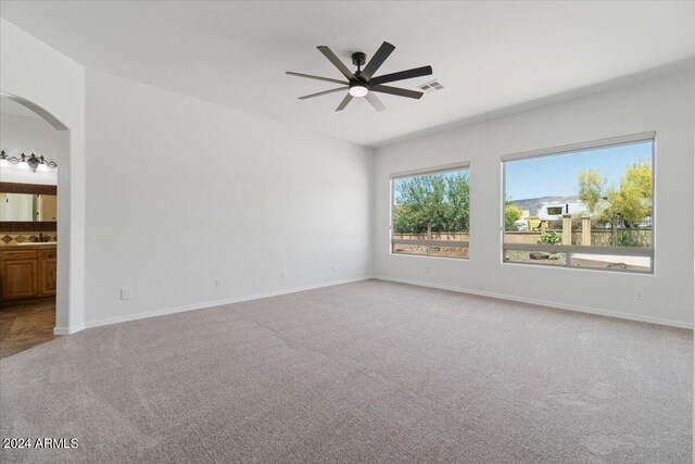 carpeted empty room with sink and ceiling fan