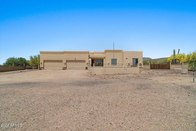 view of front of home featuring stucco siding, an attached garage, a mountain view, fence, and driveway