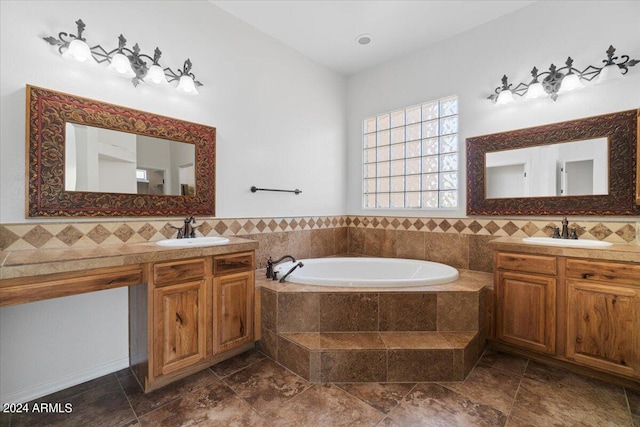 bathroom with tasteful backsplash, tiled bath, and vanity