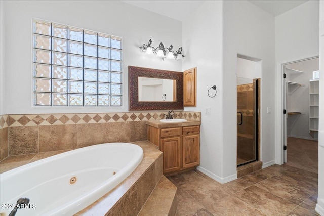 bathroom featuring tile floors, independent shower and bath, plenty of natural light, and vanity with extensive cabinet space