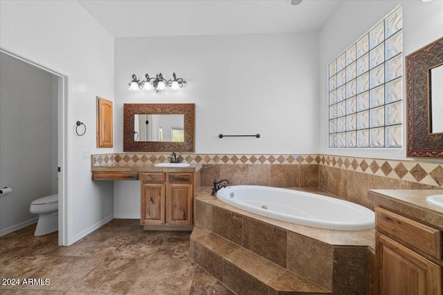 bathroom featuring a relaxing tiled bath, tile flooring, toilet, and vanity