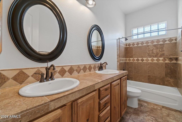 full bathroom featuring dual vanity, tile flooring, toilet, and tiled shower / bath combo