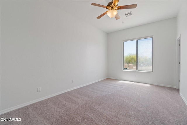 carpeted spare room featuring ceiling fan