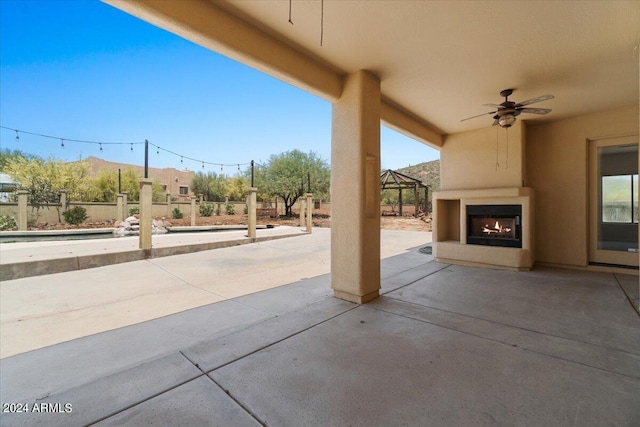 view of patio / terrace with an outdoor fireplace and ceiling fan