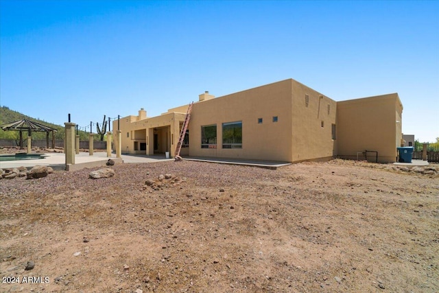 rear view of property featuring a patio area and a gazebo