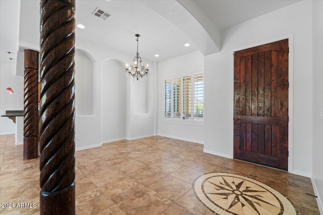 tiled entryway featuring a notable chandelier