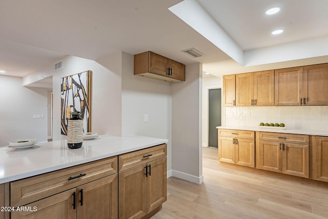 kitchen with decorative backsplash and light hardwood / wood-style flooring