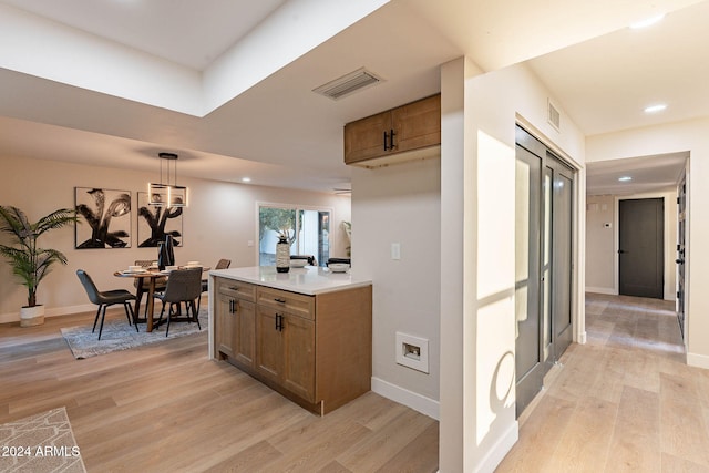 interior space featuring pendant lighting and light hardwood / wood-style floors