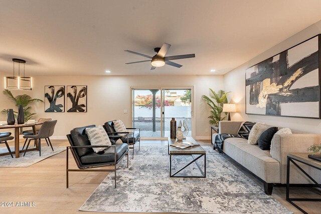 living room with ceiling fan and light hardwood / wood-style flooring