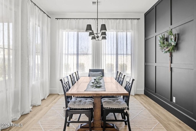 dining room with a notable chandelier and light hardwood / wood-style flooring