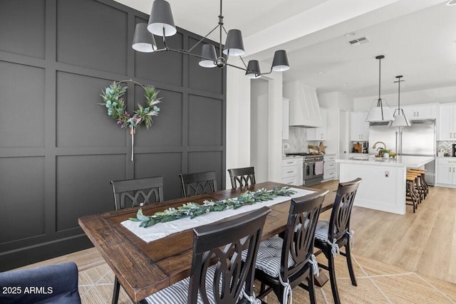 dining room featuring sink and light hardwood / wood-style floors