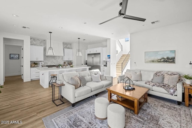 living room with ceiling fan and light wood-type flooring