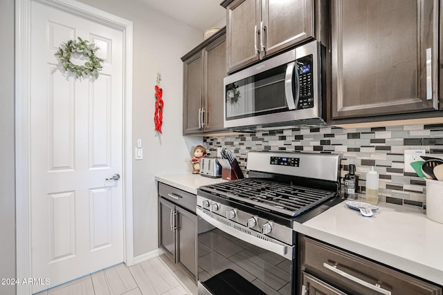 kitchen with appliances with stainless steel finishes, dark brown cabinetry, and tasteful backsplash