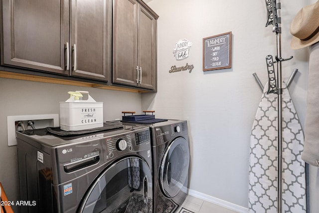 clothes washing area featuring light tile patterned flooring, cabinets, and independent washer and dryer