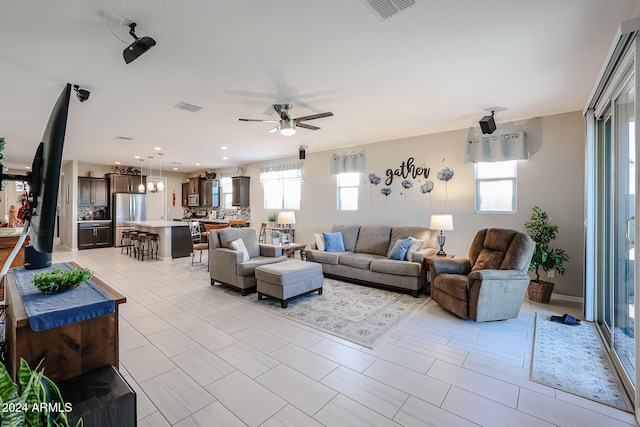 living room with ceiling fan and light tile patterned floors