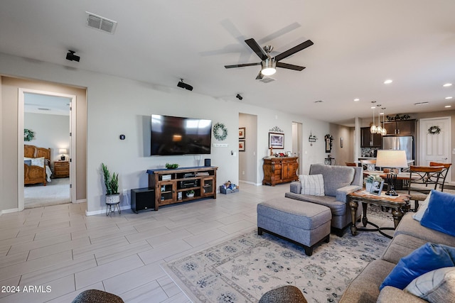 living room with ceiling fan with notable chandelier