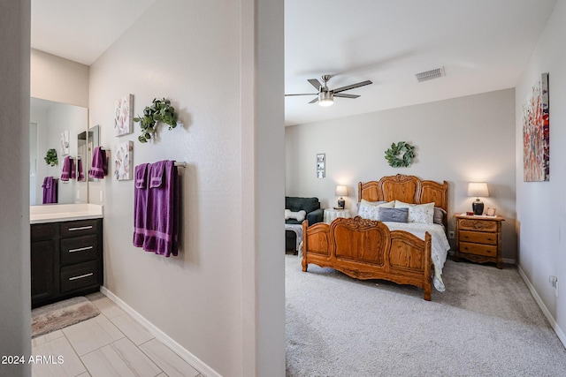 carpeted bedroom with ensuite bath and ceiling fan