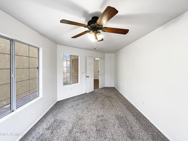 spare room featuring ceiling fan, baseboards, and carpet flooring