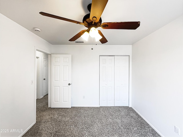 unfurnished bedroom featuring ceiling fan, visible vents, baseboards, a closet, and dark colored carpet