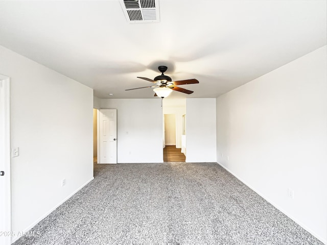 interior space featuring baseboards, visible vents, dark carpet, and a ceiling fan