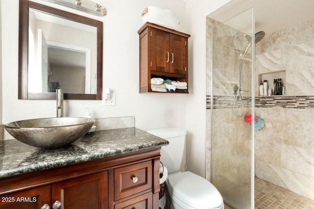 bathroom featuring tiled shower, vanity, and toilet