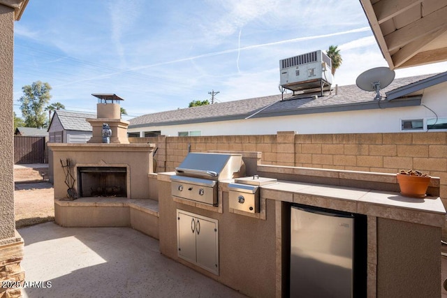 view of patio / terrace featuring an outdoor kitchen, a grill, central AC, and exterior fireplace