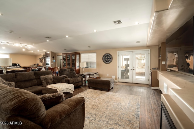 living room featuring hardwood / wood-style floors, vaulted ceiling, and french doors