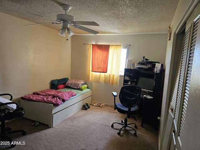 carpeted bedroom with ceiling fan and a textured ceiling