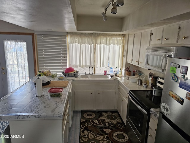 kitchen with white cabinetry, appliances with stainless steel finishes, tile countertops, and a sink