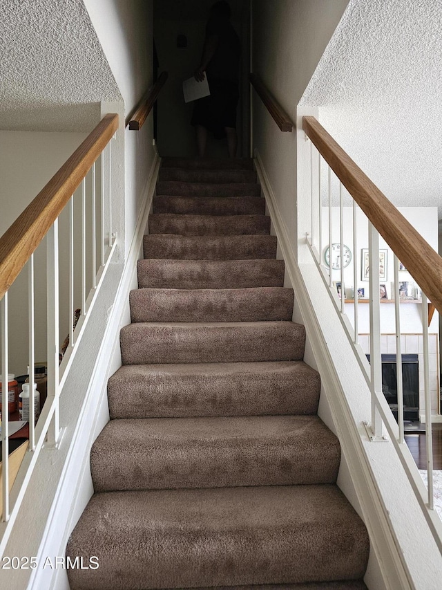 stairs featuring a textured ceiling