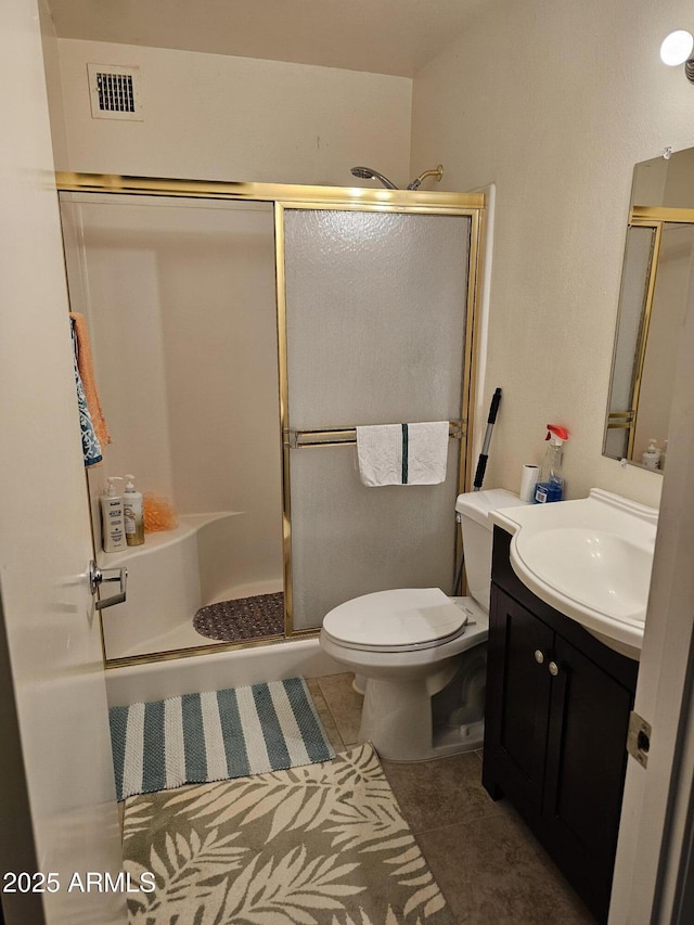 bathroom with visible vents, tile patterned flooring, vanity, toilet, and a shower stall