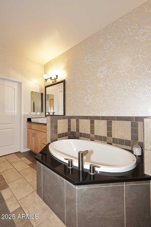 7601 E Indian Bend Rd Unit 1040, Scottsdale, AZ 85250 - bathroom with wallpapered walls, vanity, a bath, tile patterned flooring, and tile walls