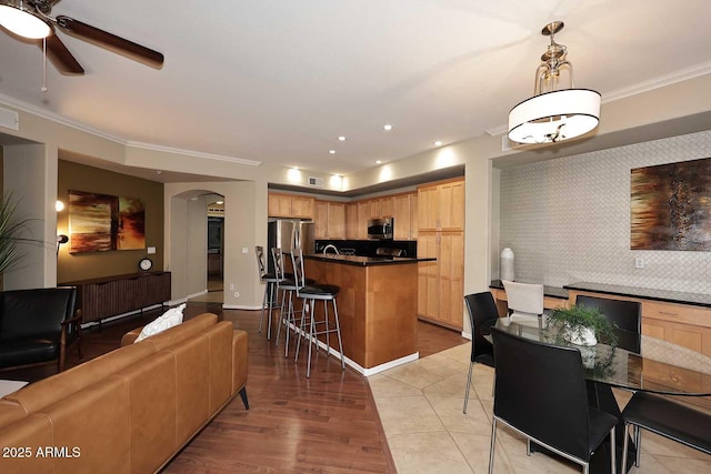 7601 E Indian Bend Rd Unit 1040, Scottsdale, AZ 85250 - living room featuring arched walkways, ceiling fan, ornamental molding, light wood finished floors, and recessed lighting