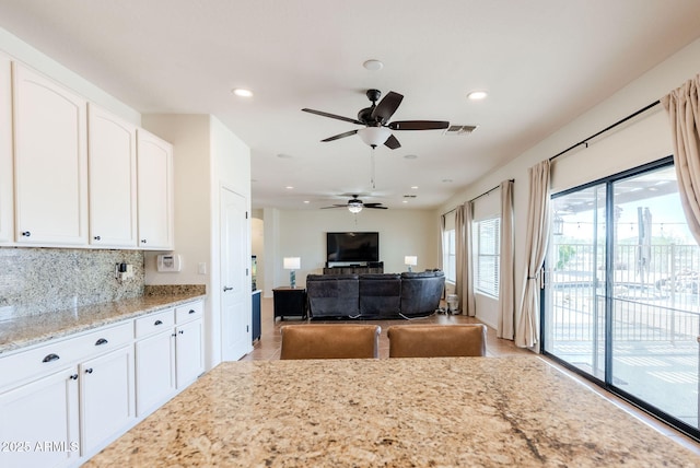 9998 W Prospector Dr, Queen Creek, AZ 85144 - kitchen with ceiling fan, white cabinets, light stone counters, recessed lighting, and light tile patterned flooring