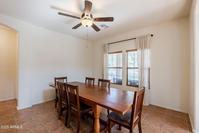 9998 W Prospector Dr, Queen Creek, AZ 85144 - dining room featuring arched walkways, a ceiling fan, light tile patterned floors, and baseboards