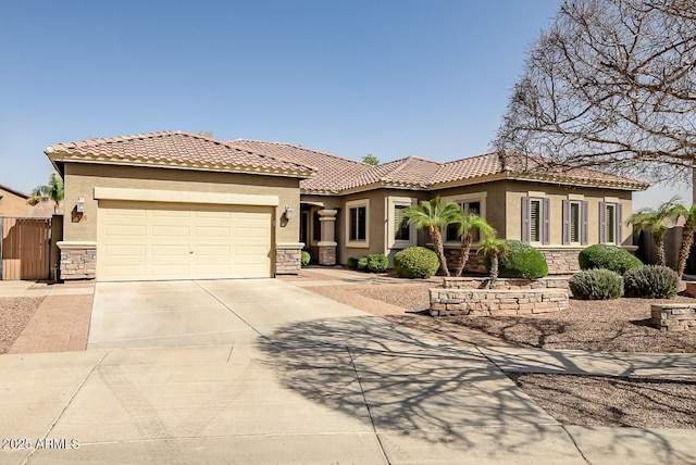 mediterranean / spanish-style home featuring stone siding, an attached garage, driveway, and stucco siding