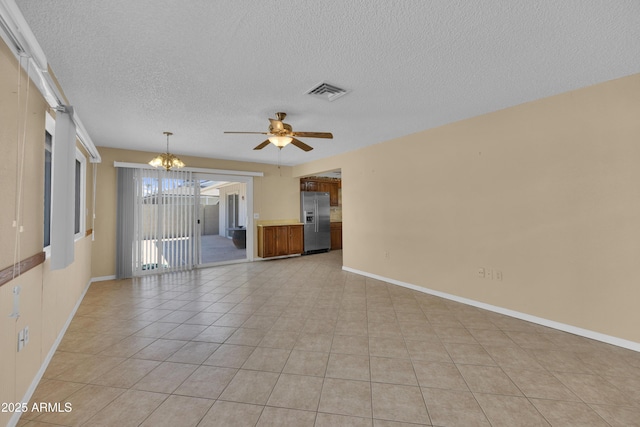 unfurnished living room featuring ceiling fan with notable chandelier, light tile patterned floors, and a textured ceiling