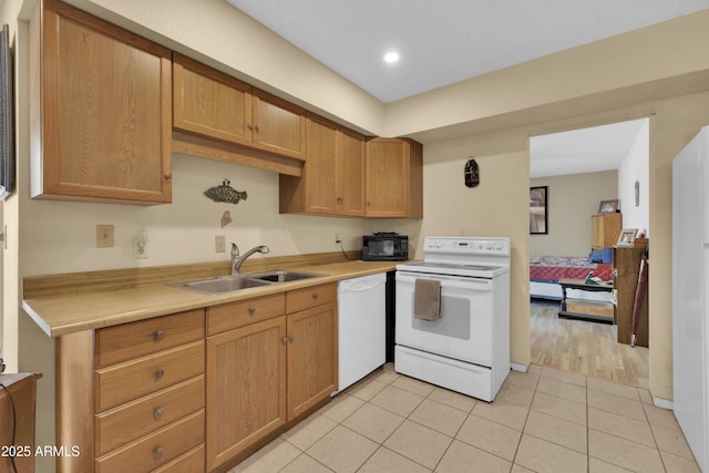 kitchen with sink, light tile patterned flooring, and white appliances