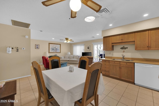 tiled dining area featuring a textured ceiling, ceiling fan, and sink