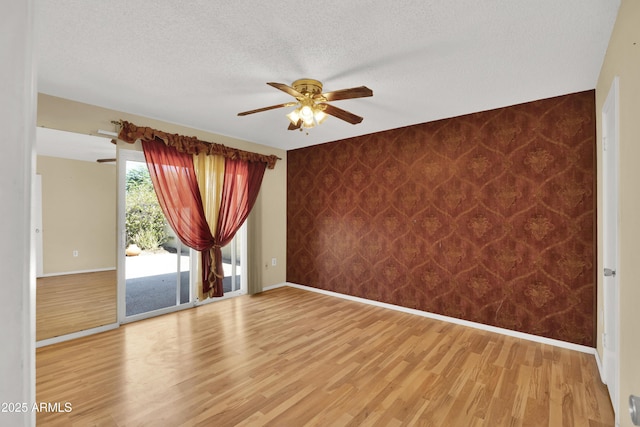 unfurnished room featuring hardwood / wood-style floors, a textured ceiling, and ceiling fan